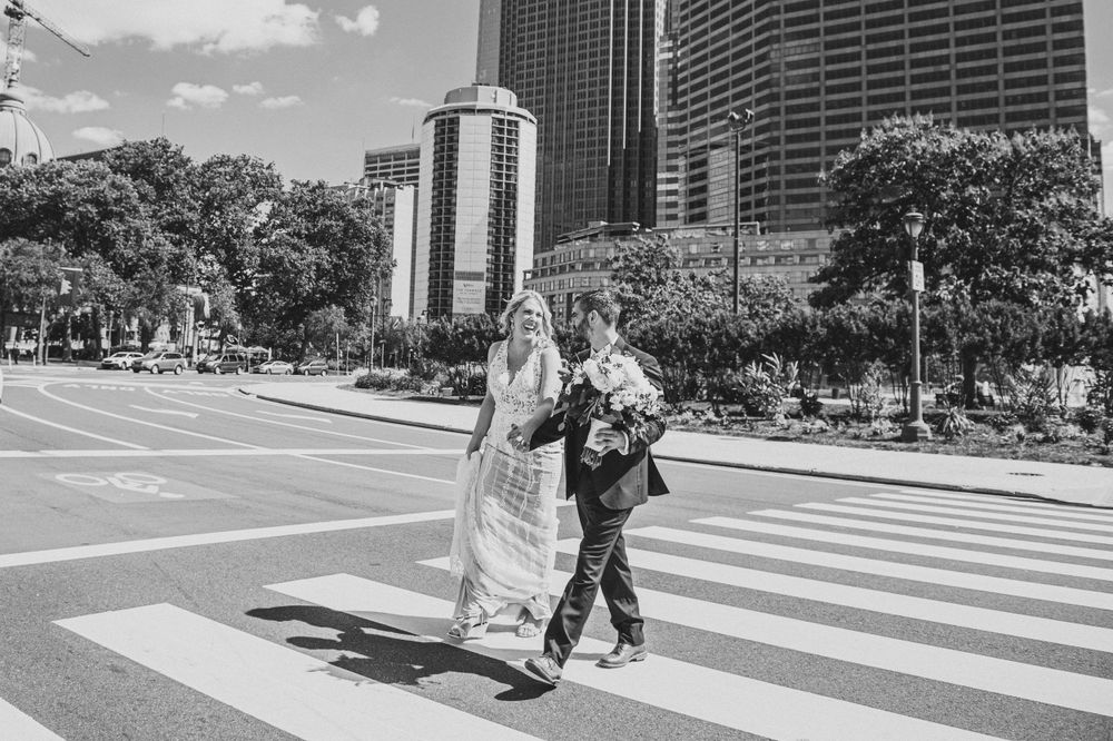 Two people walk across a crosswalk in downtown Chicago with tall buildings in the background.