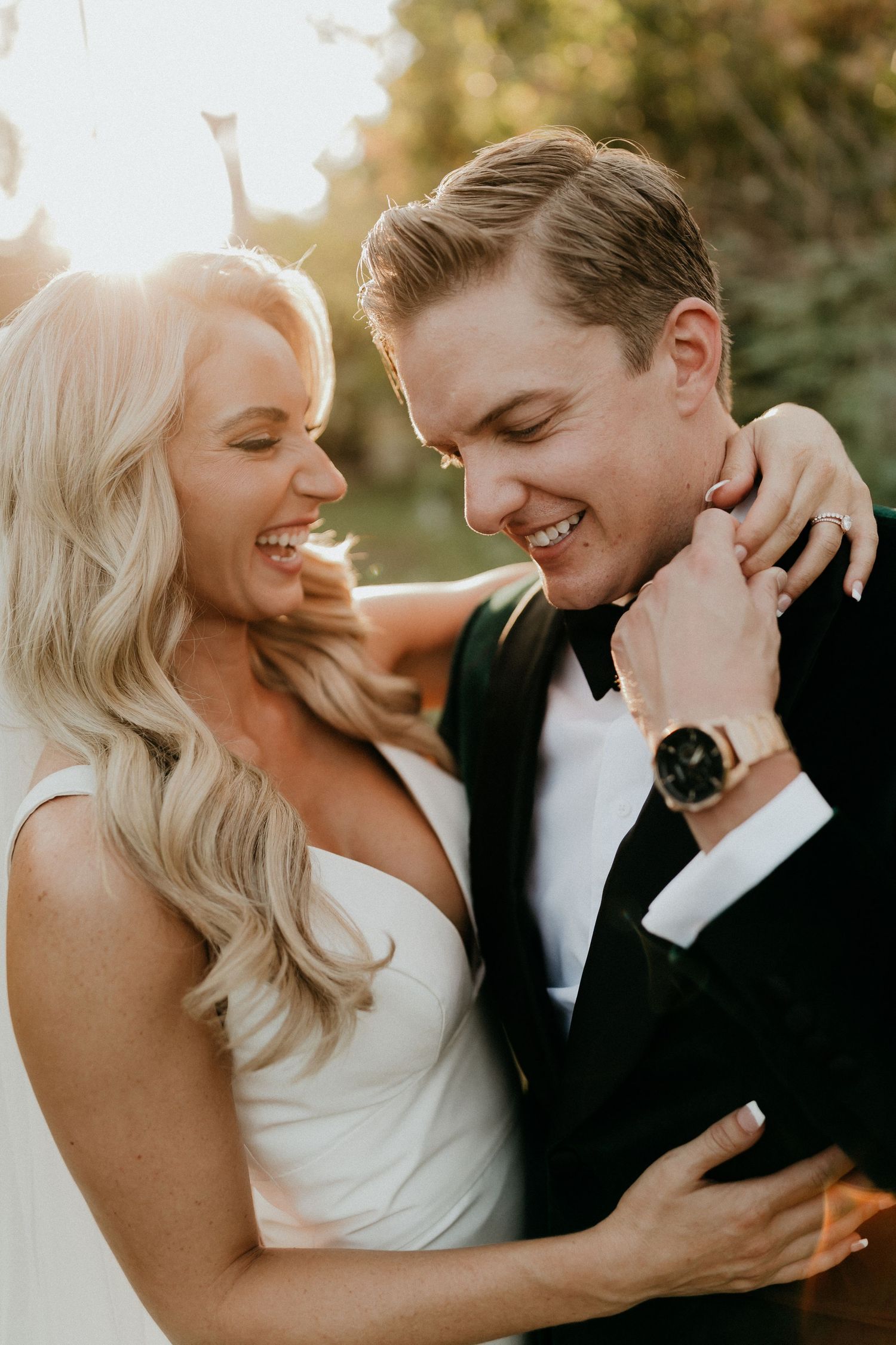 Couple shares joyful moment in formal attire during outdoor wedding photoshoot.
