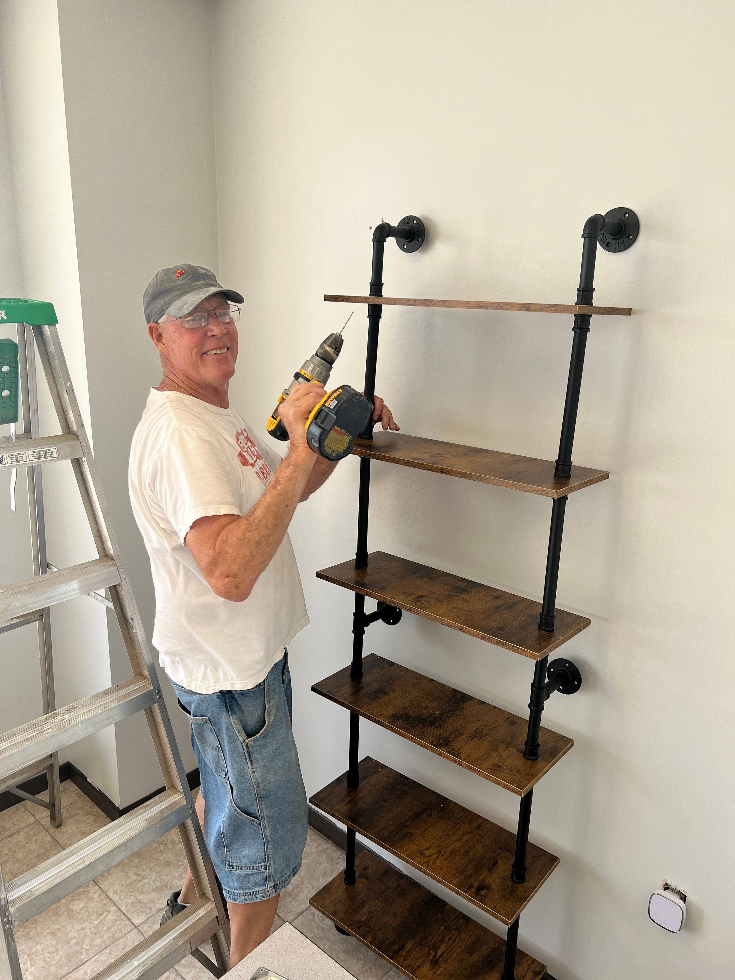 Installation of industrial-style wooden shelving units on white wall.