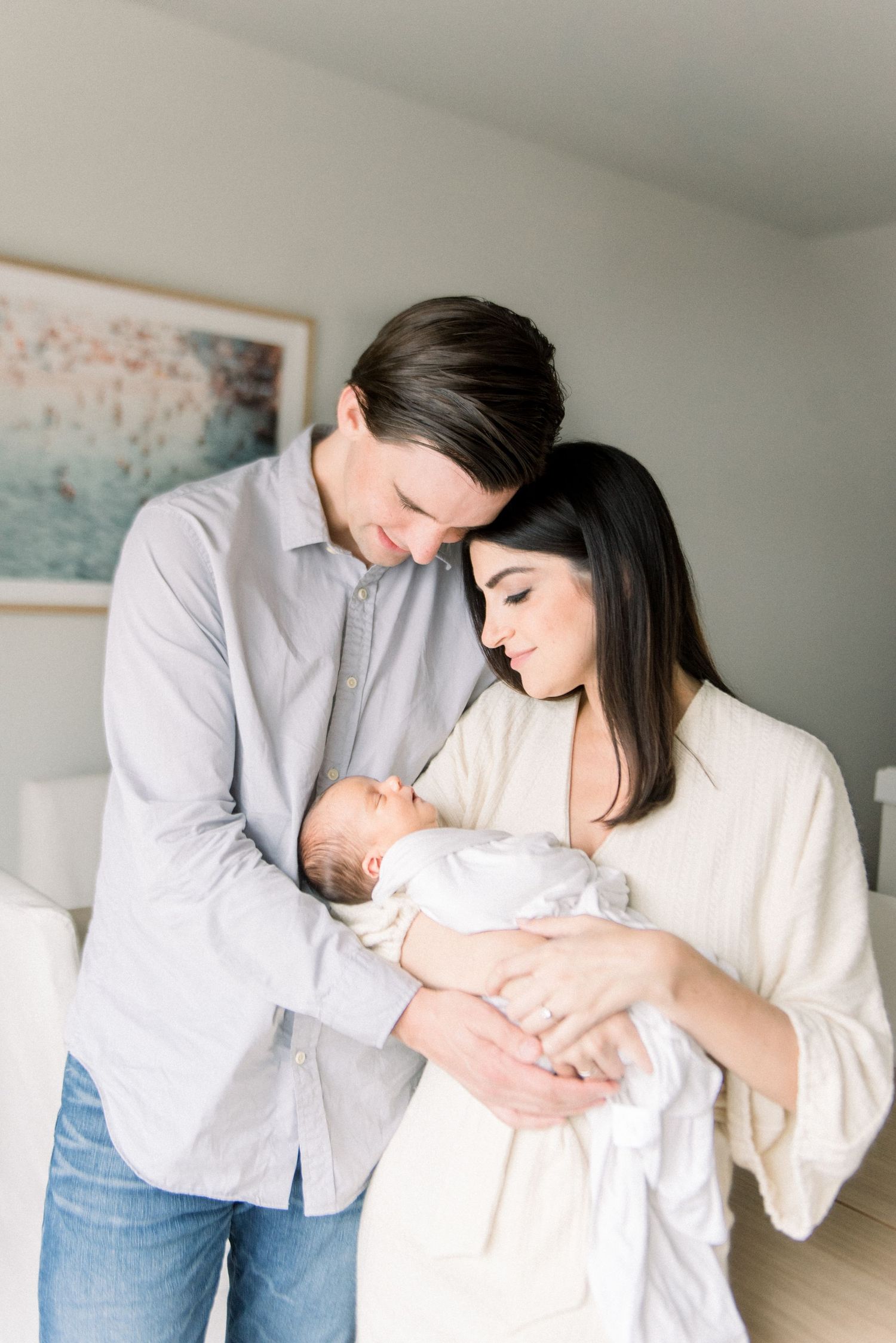 mom and dad standing holding baby at newborn session in washington DC