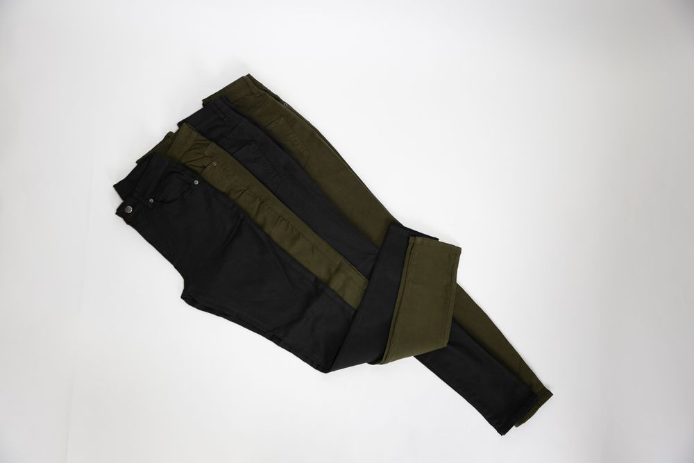 balck and olive green jeans with one leg each kicked up