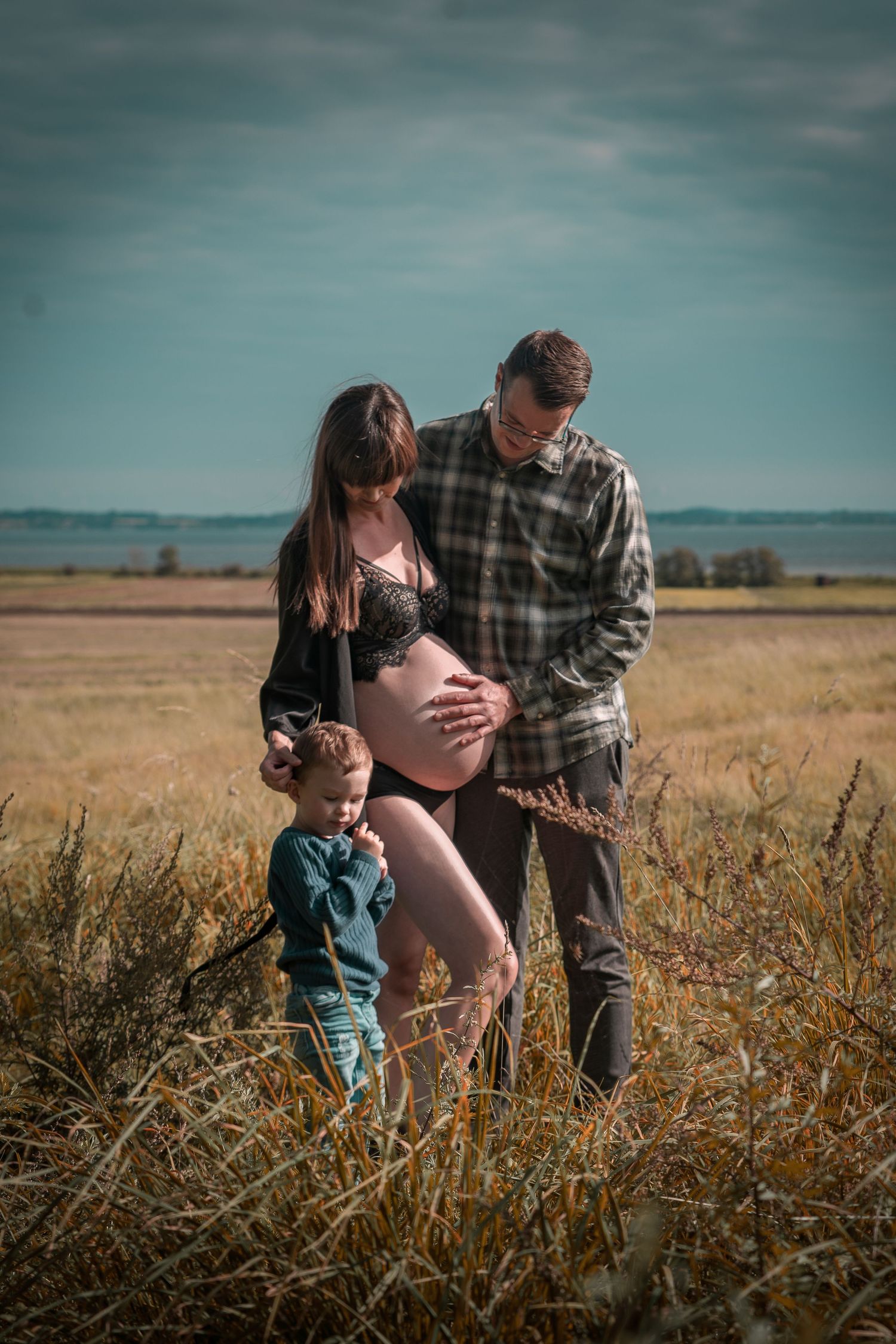 Gravid familieportræt i naturen. Ventetidsfoto af kommende forældre og barn. Gravid fotograf i Jægerspris, Frederikssund & Nordsjælland.