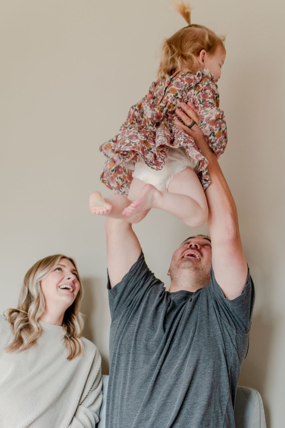 Dad throws his daughter in the air, creating laughter in his home.