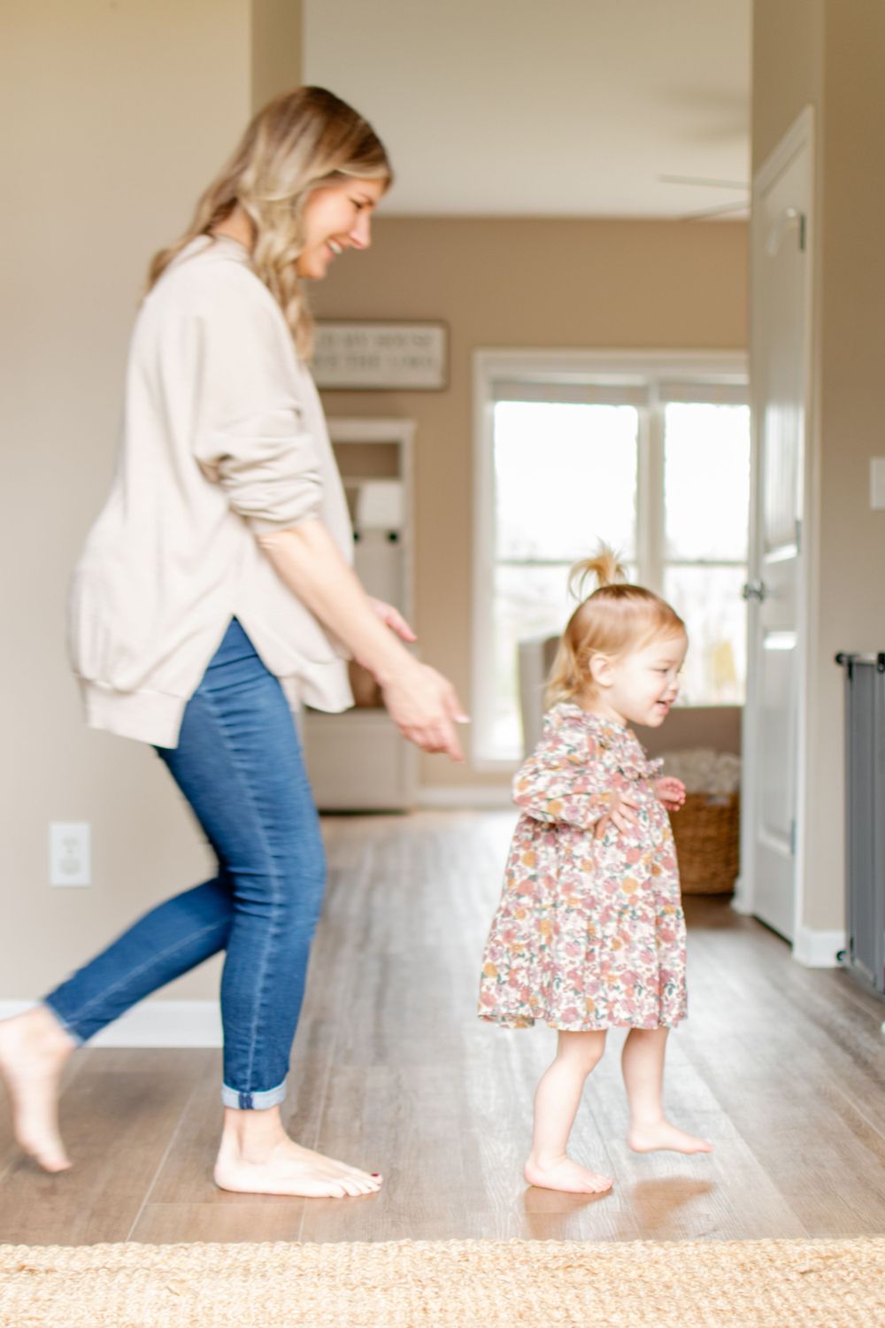 A pregnant mom playfully chases her toddler to the playroom.