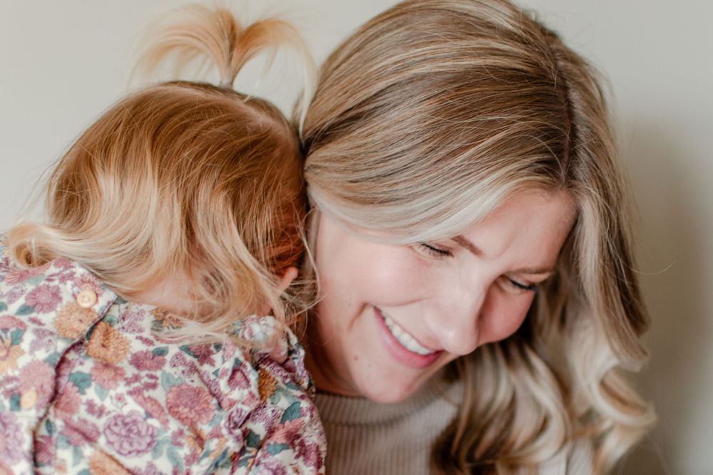 The joy shines on a mother's face when her daughter snuggles close.