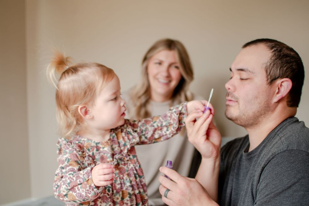 A dad blow tiny bubbles for his daughter as she reaches for the wand.