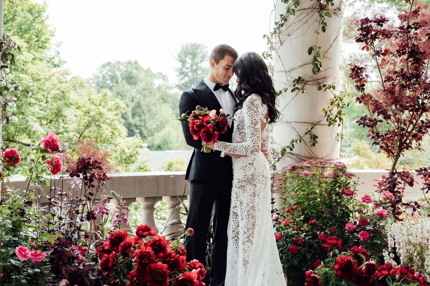 Bride and groom hug close on the Library Terrace of the Elkins Estate.