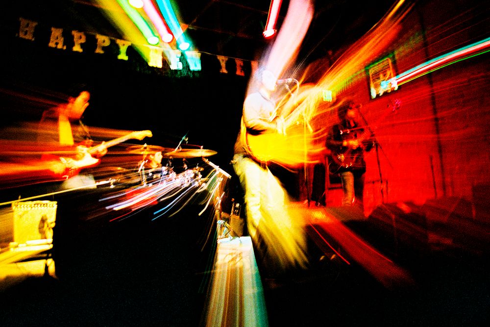 Abstract motion blur photograph with red and yellow streaks of light and a Happy New Year sign.