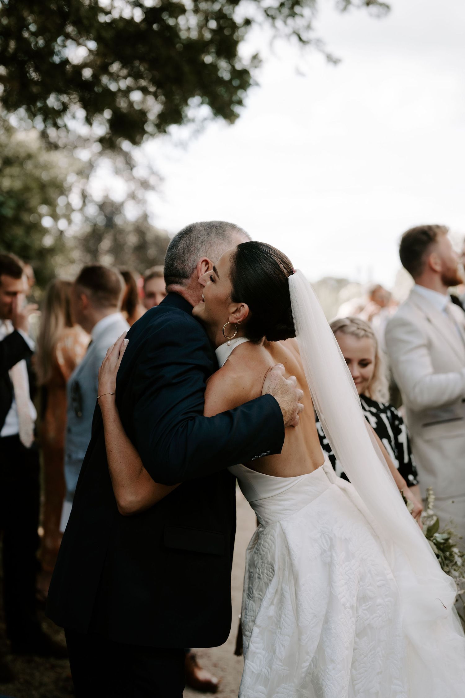 bride hugging wedding guests at st Nicholas church in Oxfordshire