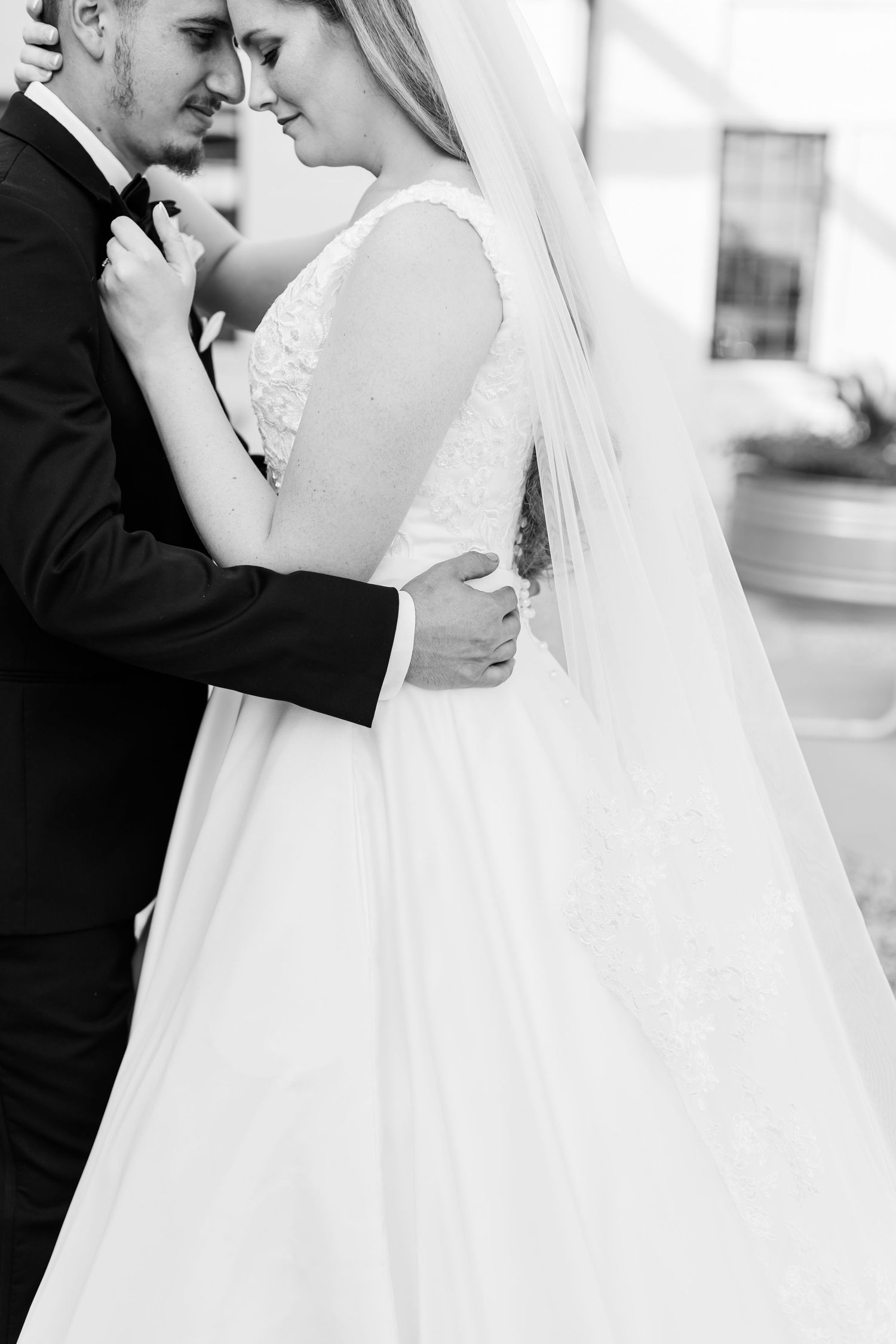 Elegant black and white wedding portraits showing tender moments between newlyweds.