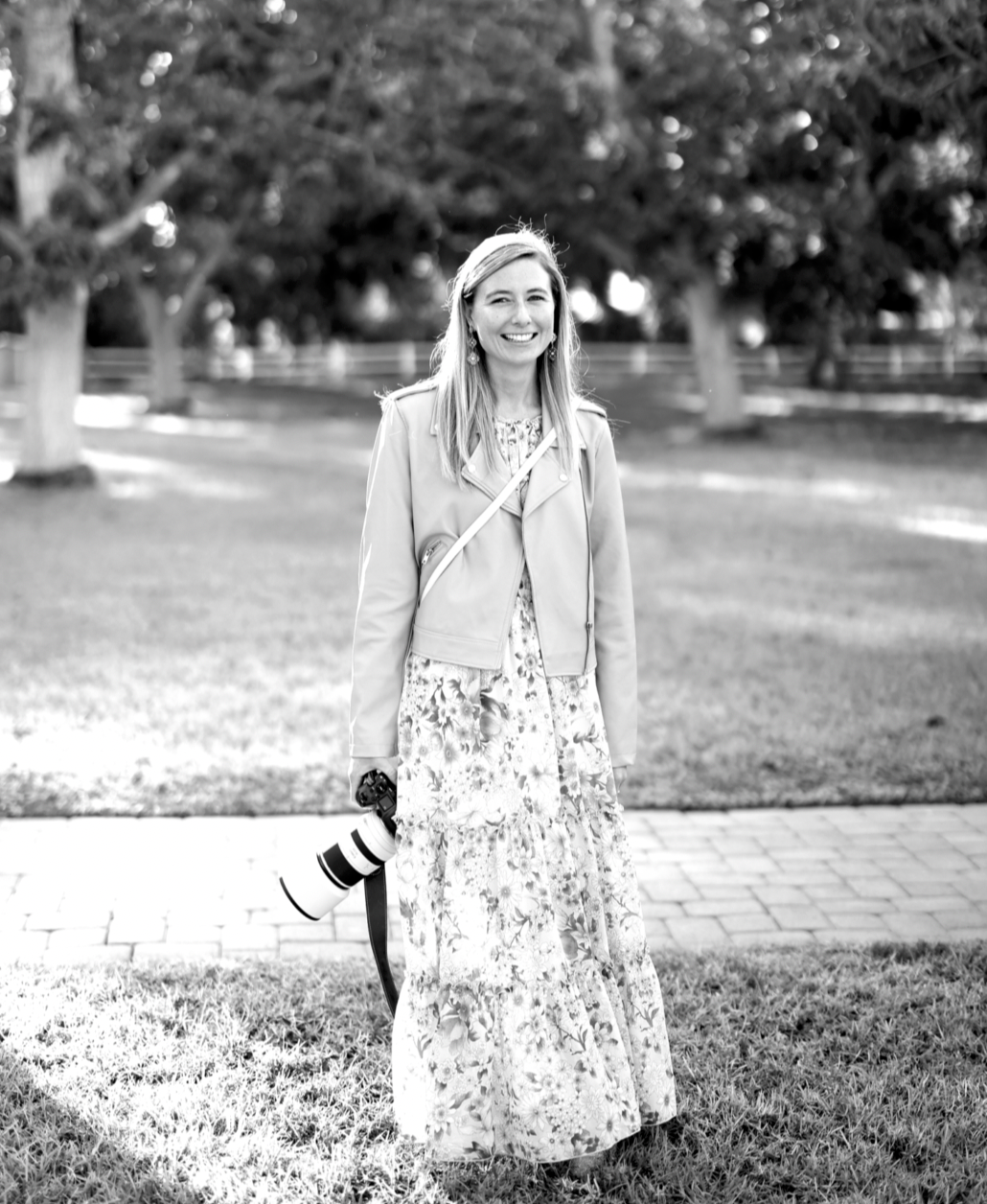 A person in a floral dress walks through a park on a sunny day.