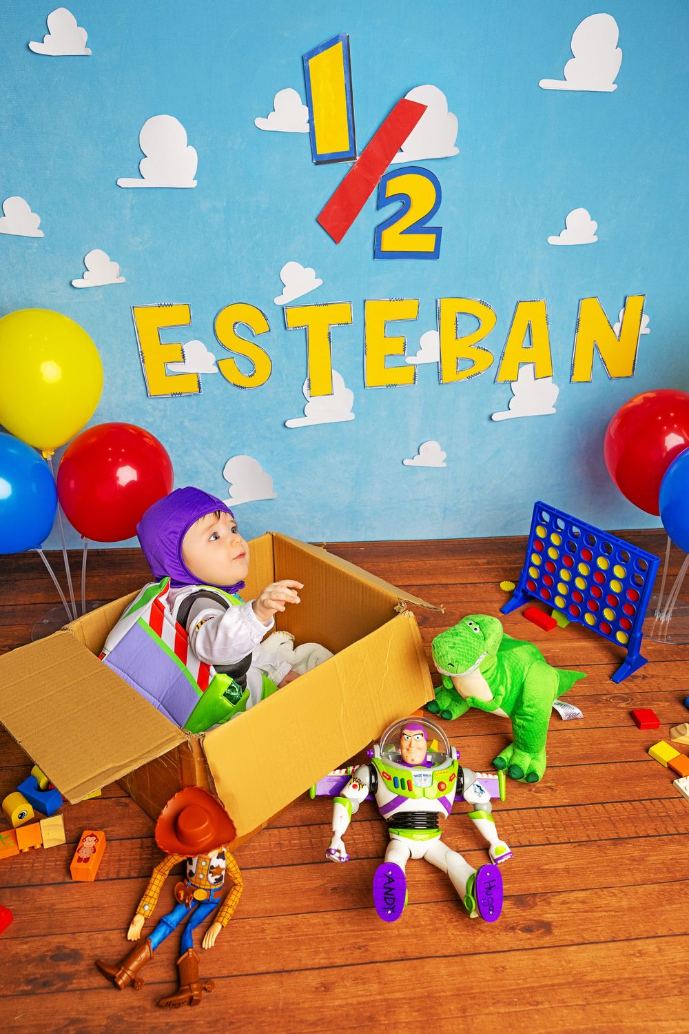 Toy Story themed birthday display with cardboard box, toys and colorful balloons.