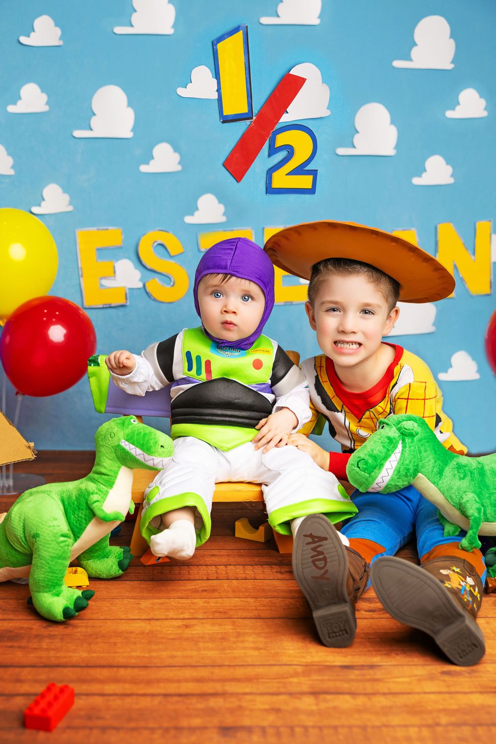 Toy Story themed photoshoot with green dinosaur toys and colorful balloons.