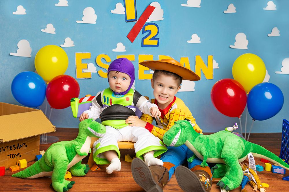Toy Story themed birthday scene with dinosaurs and balloons against blue background.