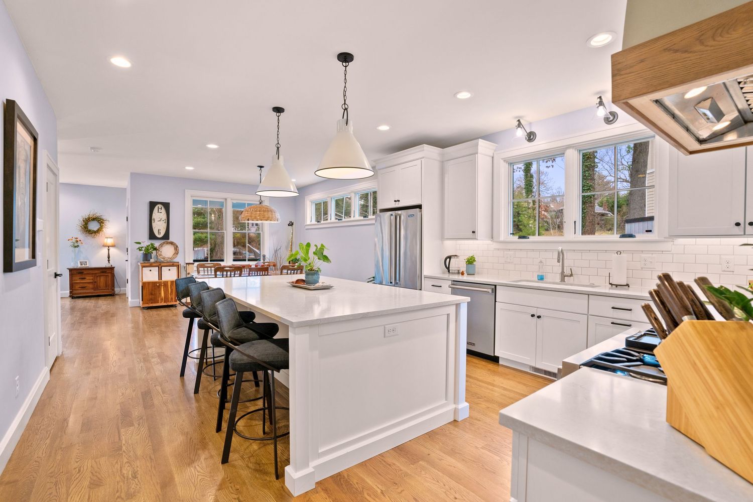 Asheville, NC. Luxury kitchen with large island, clear windows, and wood flooring. By Virtually Calhoun