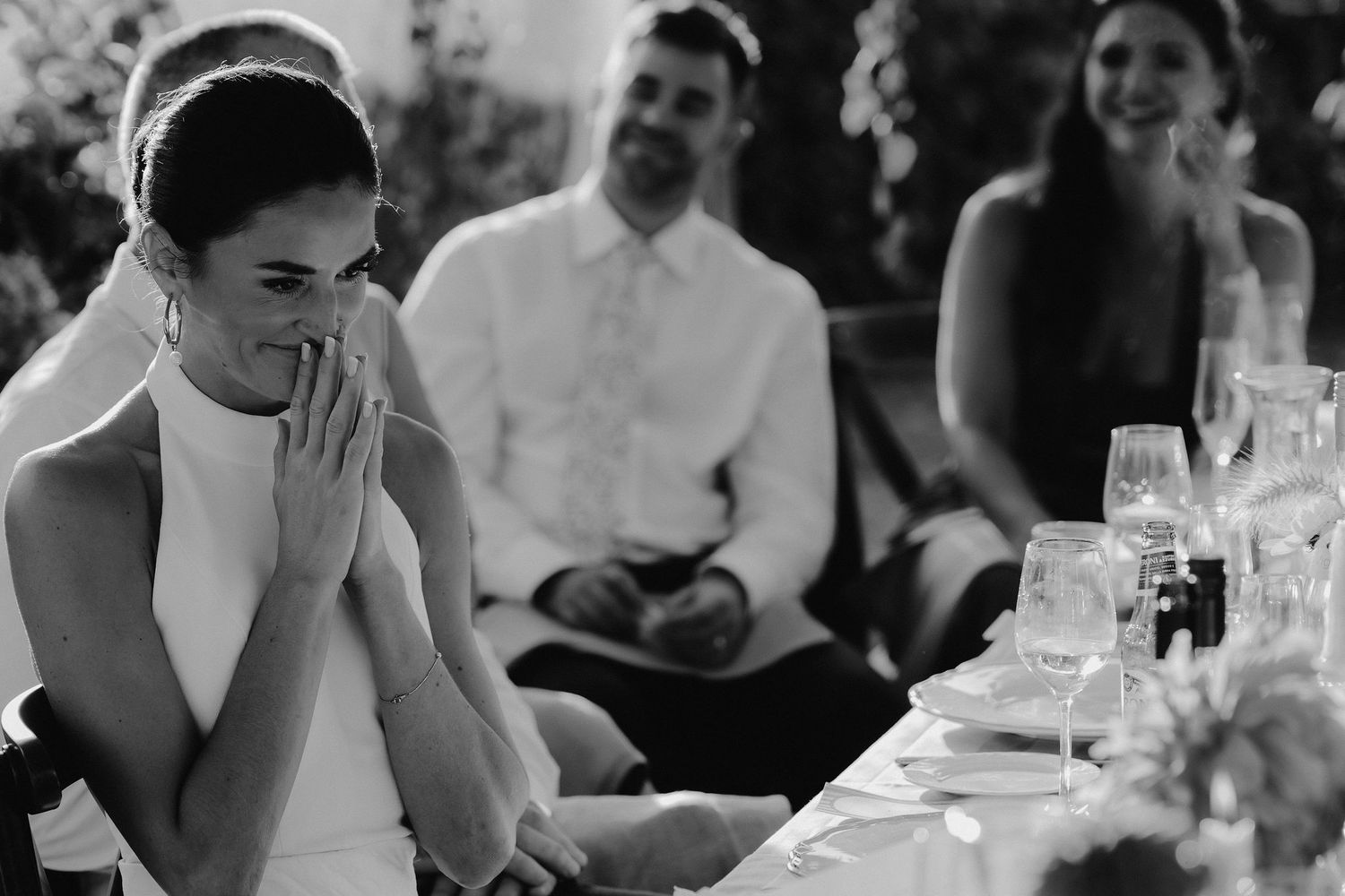 bride holding hands to her face during grooms speech at their marquee wedding in islip in oxfordshire