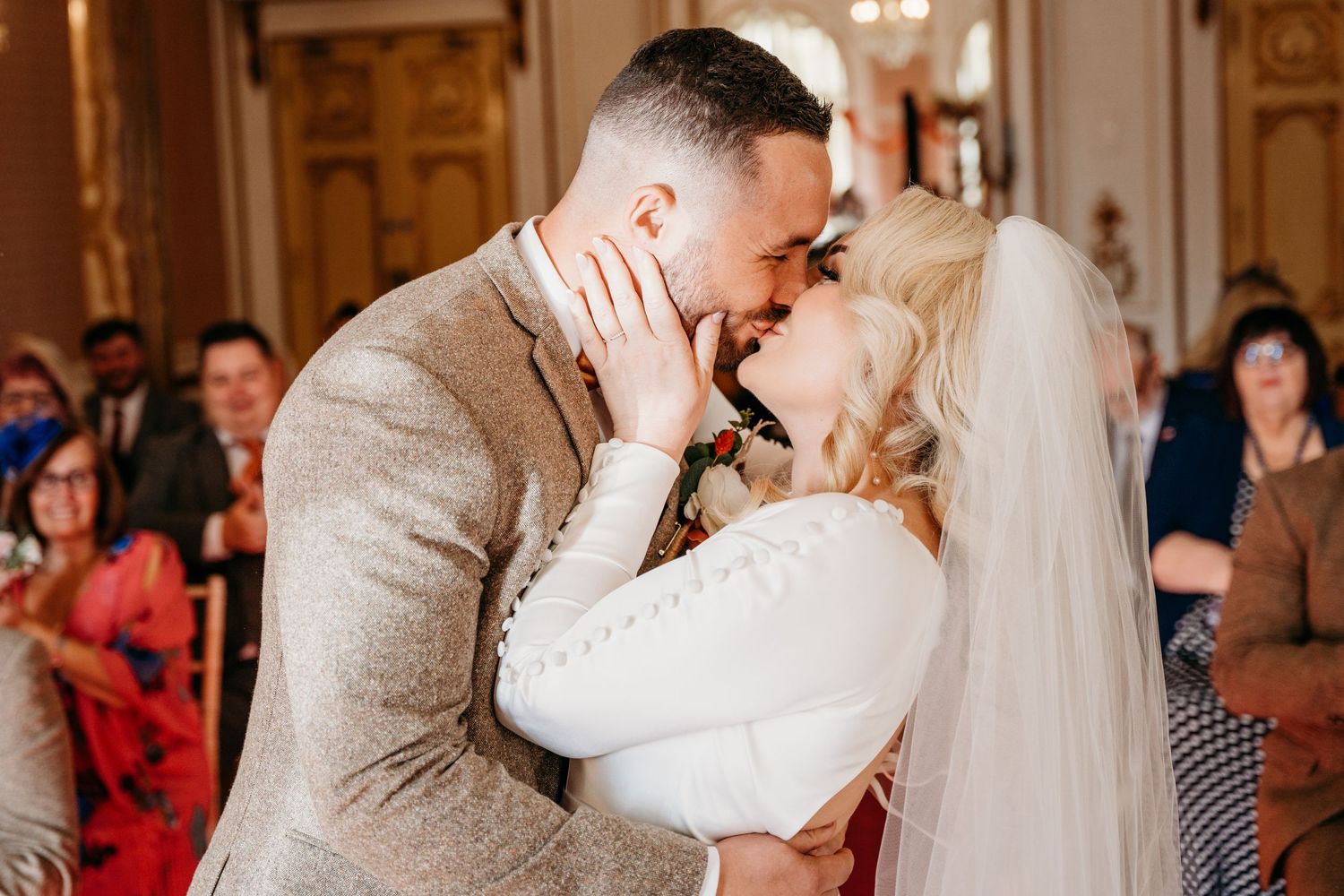 A tender moment shared during a wedding ceremony in a beautifully decorated venue.