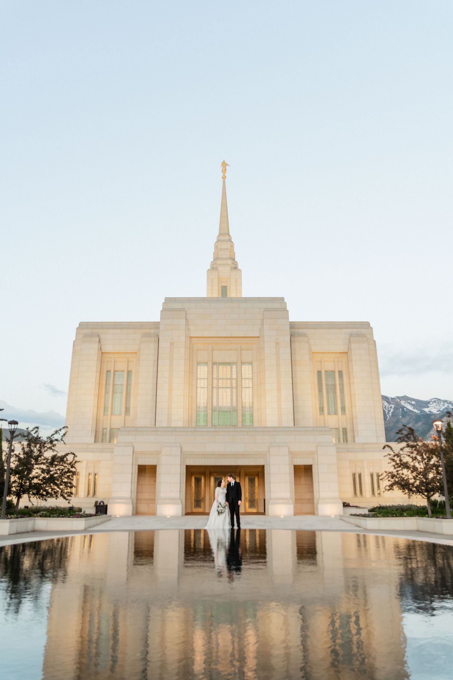 Mormon temple in Utah with reflection pool at sunset creating a symmetrical view.
