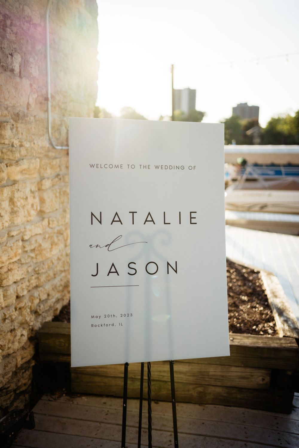 Modern minimalist wedding welcome sign for Natalie and Jason displayed at outdoor venue.