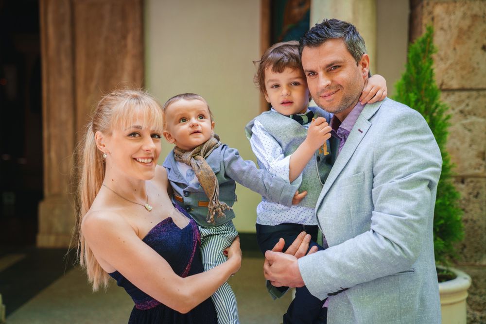 Family portrait taken outside a church building during a special occasion.