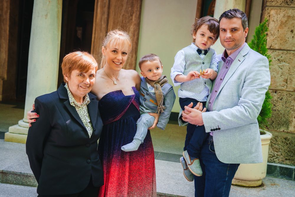 Family group photo outside church entrance during special occasion.