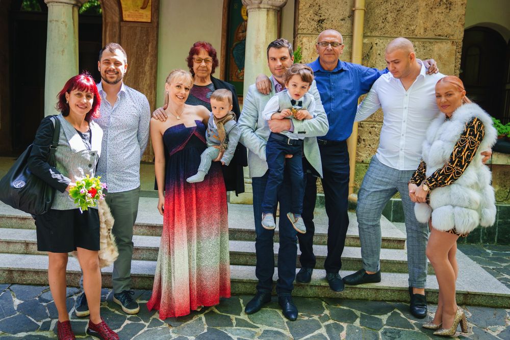 Extended family gathering on church steps for group photo during celebration.