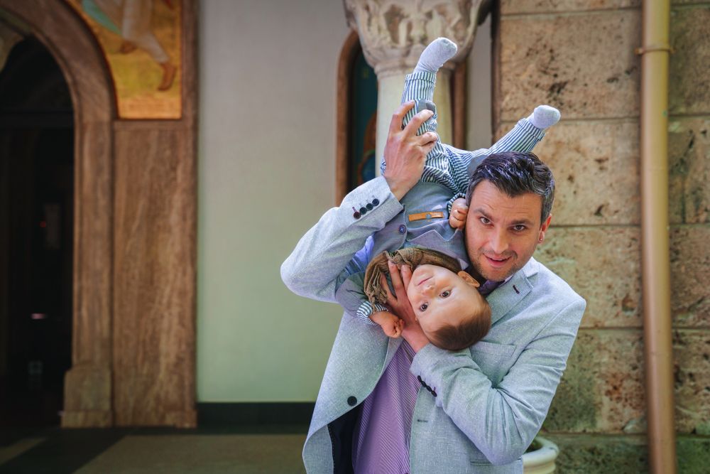 Playful moment captured inside a historic building with stone columns and arched doorways.