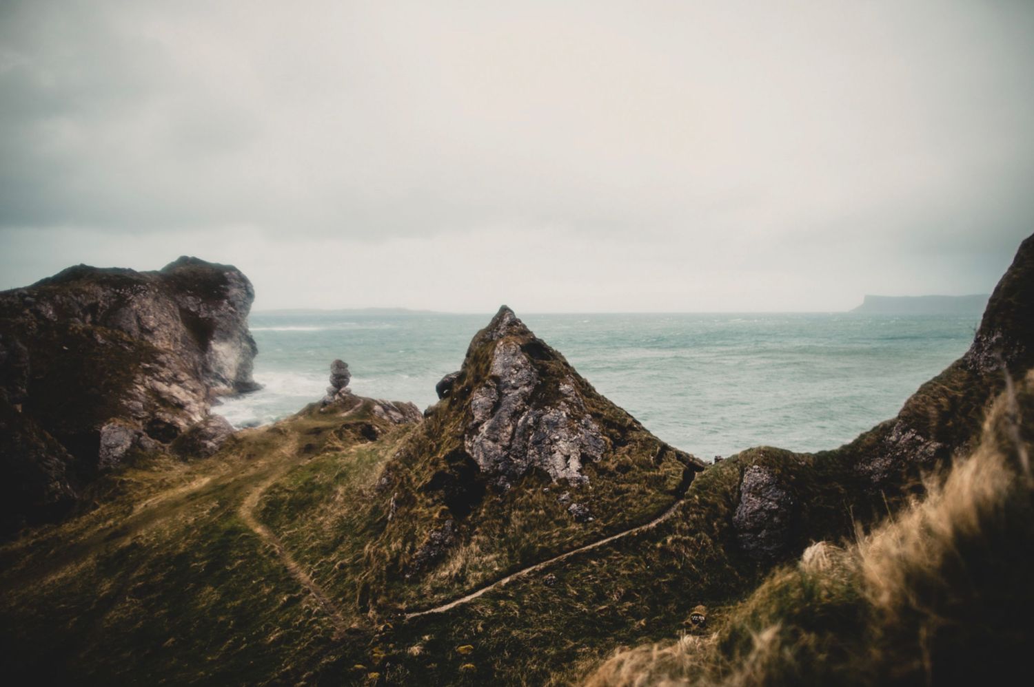 Rugged coastal landscape with dramatic cliffs and winding paths overlooking the ocean.