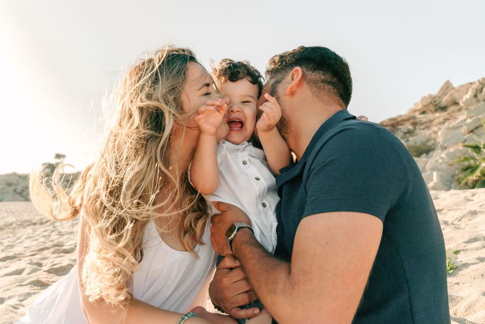 A heartwarming family embrace captured during a sunset beach photoshoot.