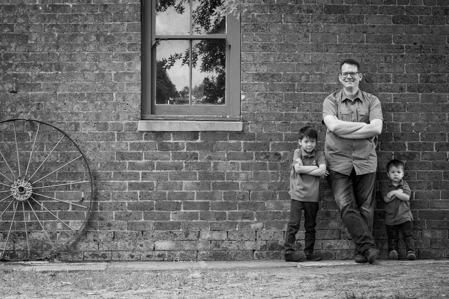 Dad with young boys against a wall