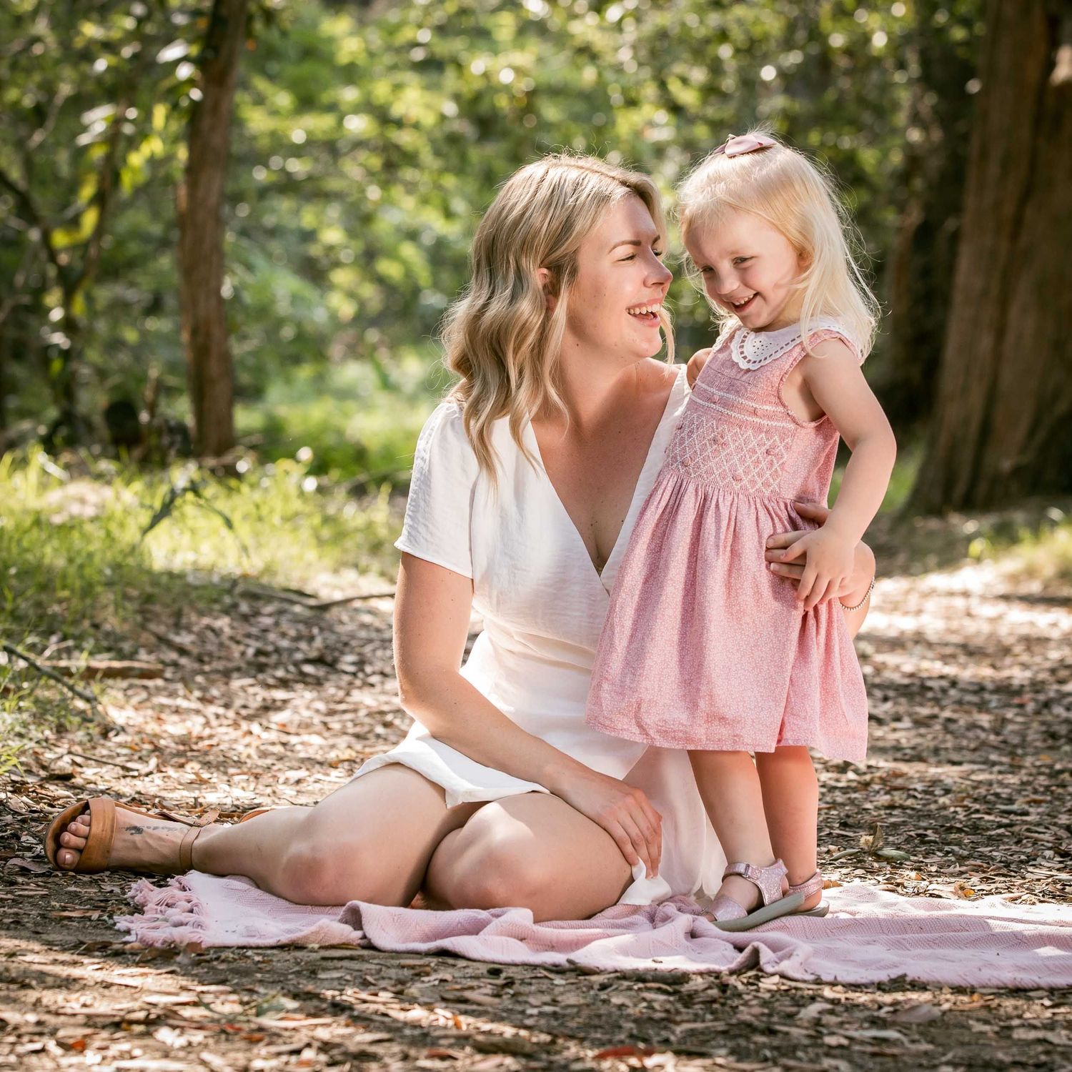 Mum talking to toddler in pink dress