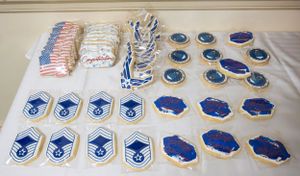 Military rank insignia patches and decorative emblems displayed on white tablecloth.
