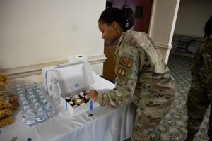 Service member preparing refreshments at a military ceremony.