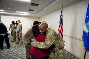 Emotional military ceremony with service member embracing attendee.