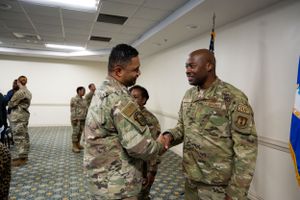 Military personnel engaged in conversation during formal ceremony.