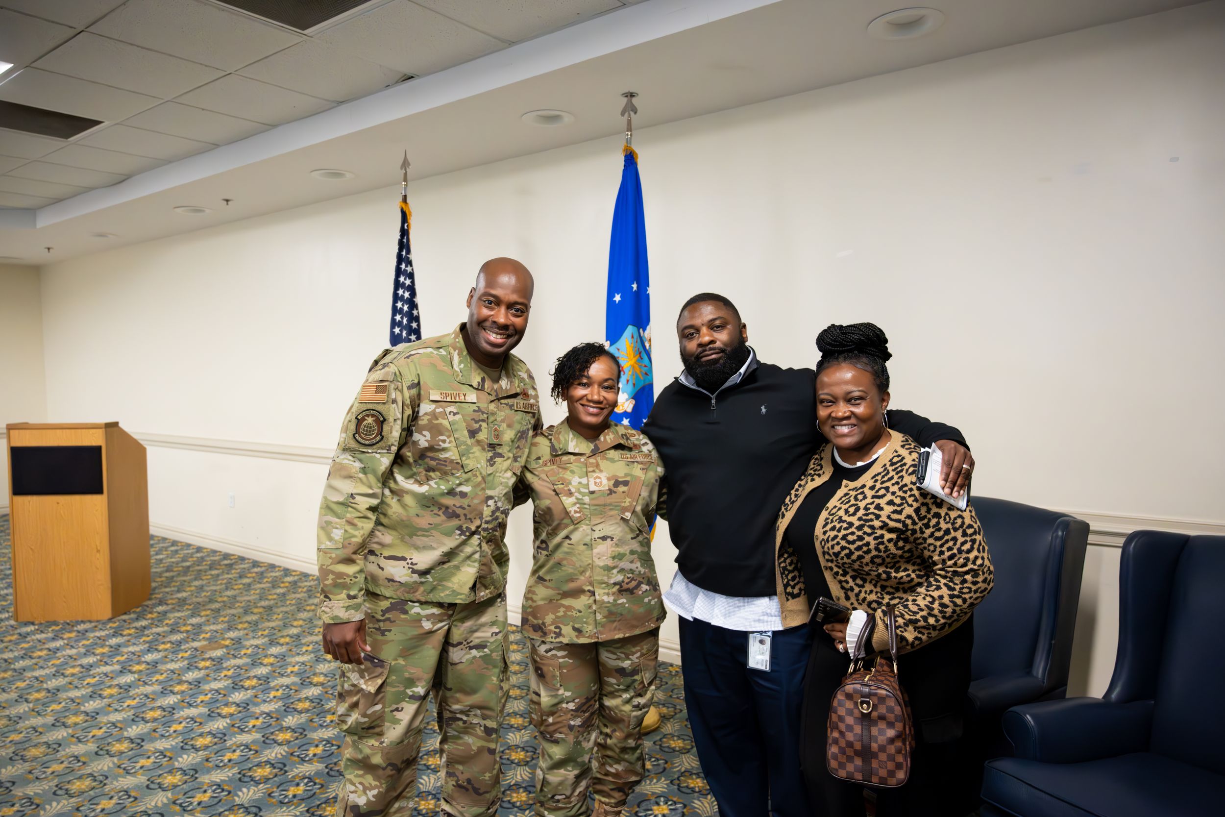 Military members engage in friendly conversation during an indoor gathering.