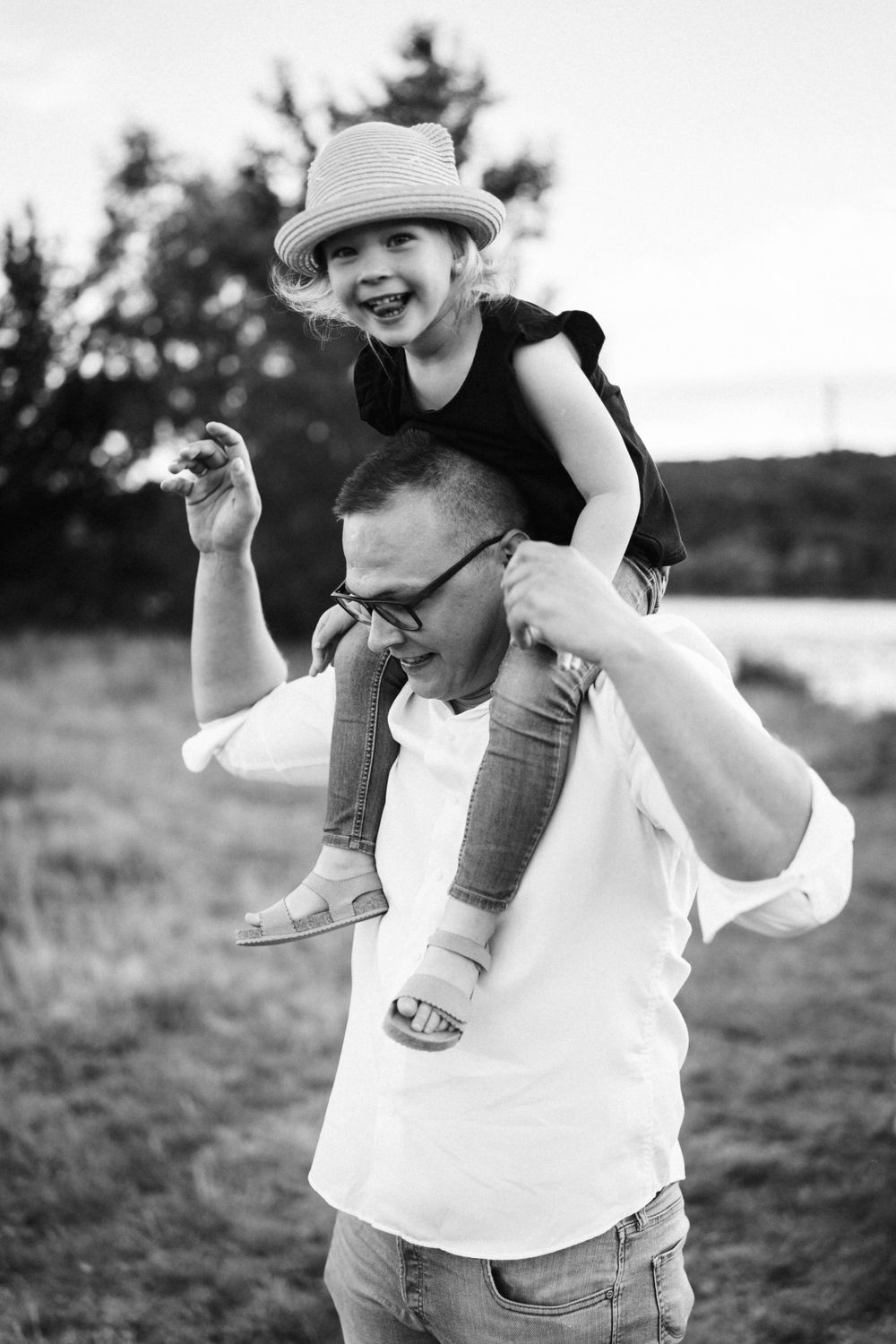 A joyful shoulder ride moment captured in black and white outdoors.