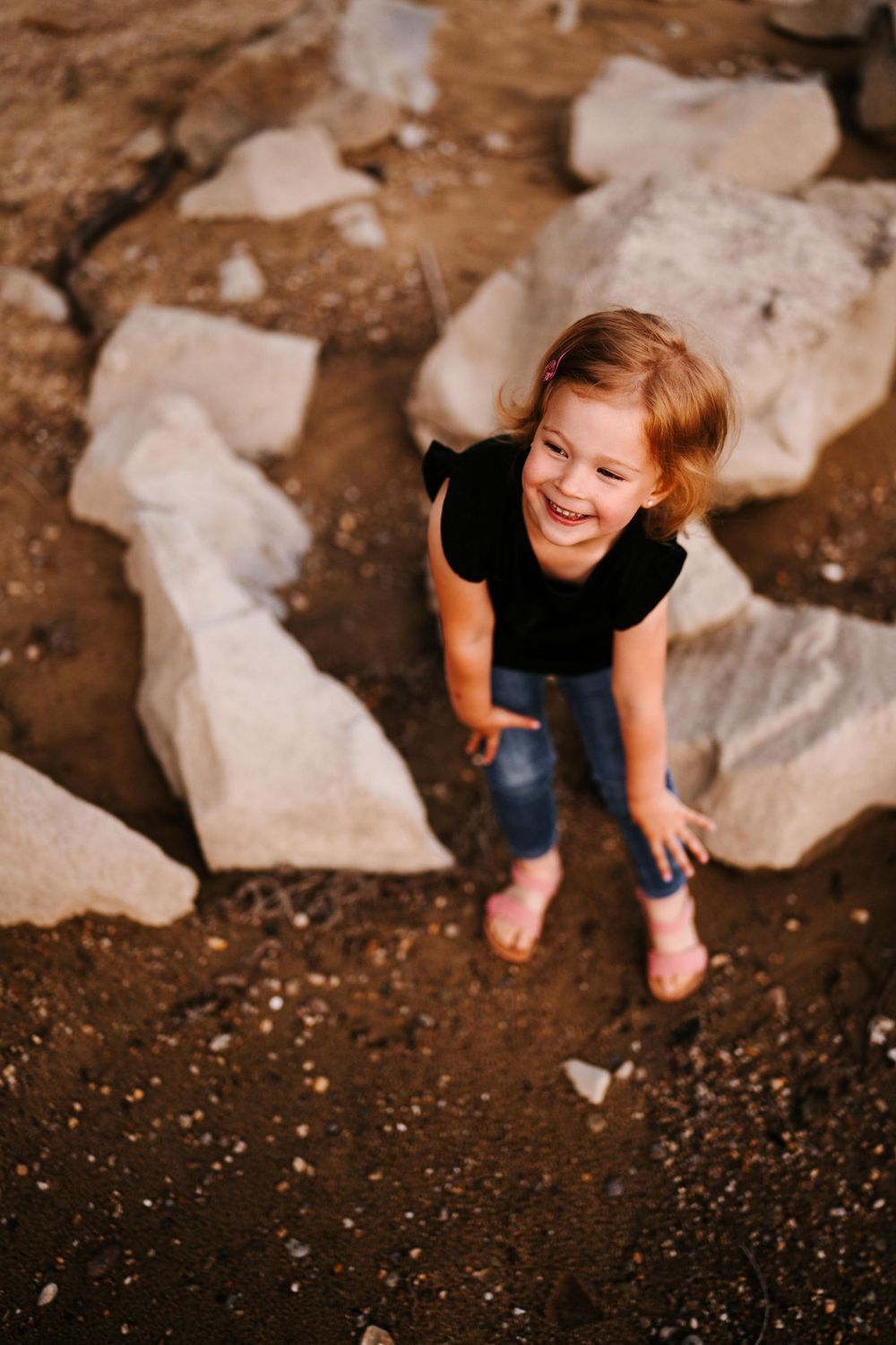 A joyful moment captured outdoors among scattered white rocks.