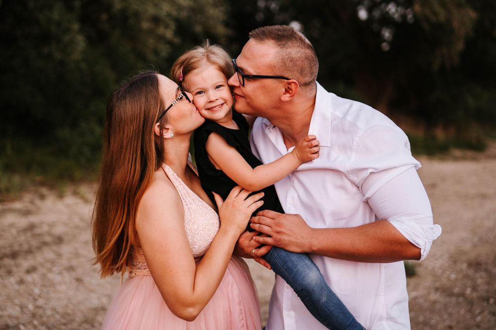 An affectionate outdoor family portrait showing pure joy and laughter during a sunset photo session.