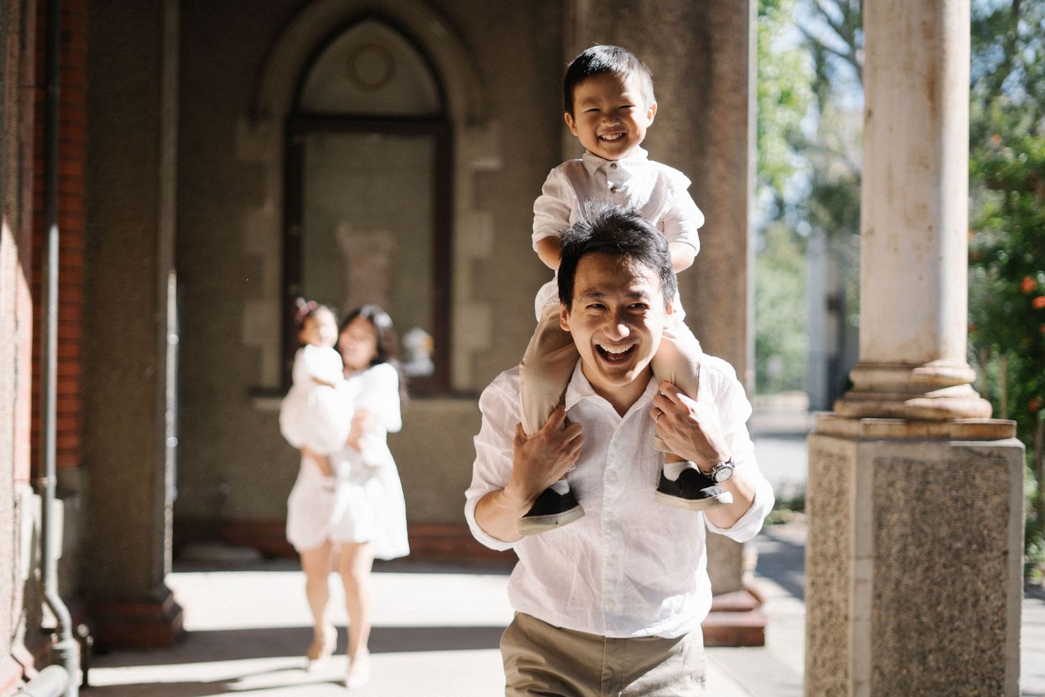Dad smiling as he carries his daughter on his shoulders. Abbotsford convent, Melbourne. Example of family photography by WhySoGeneric.