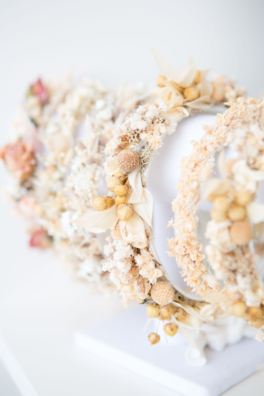 Delicate floral crown made with dried flowers and leaves in soft peachy tones.