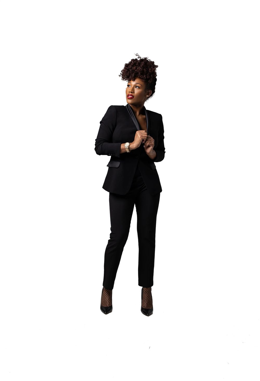 Sophisticated full-length portrait in black tailored suit against white background.