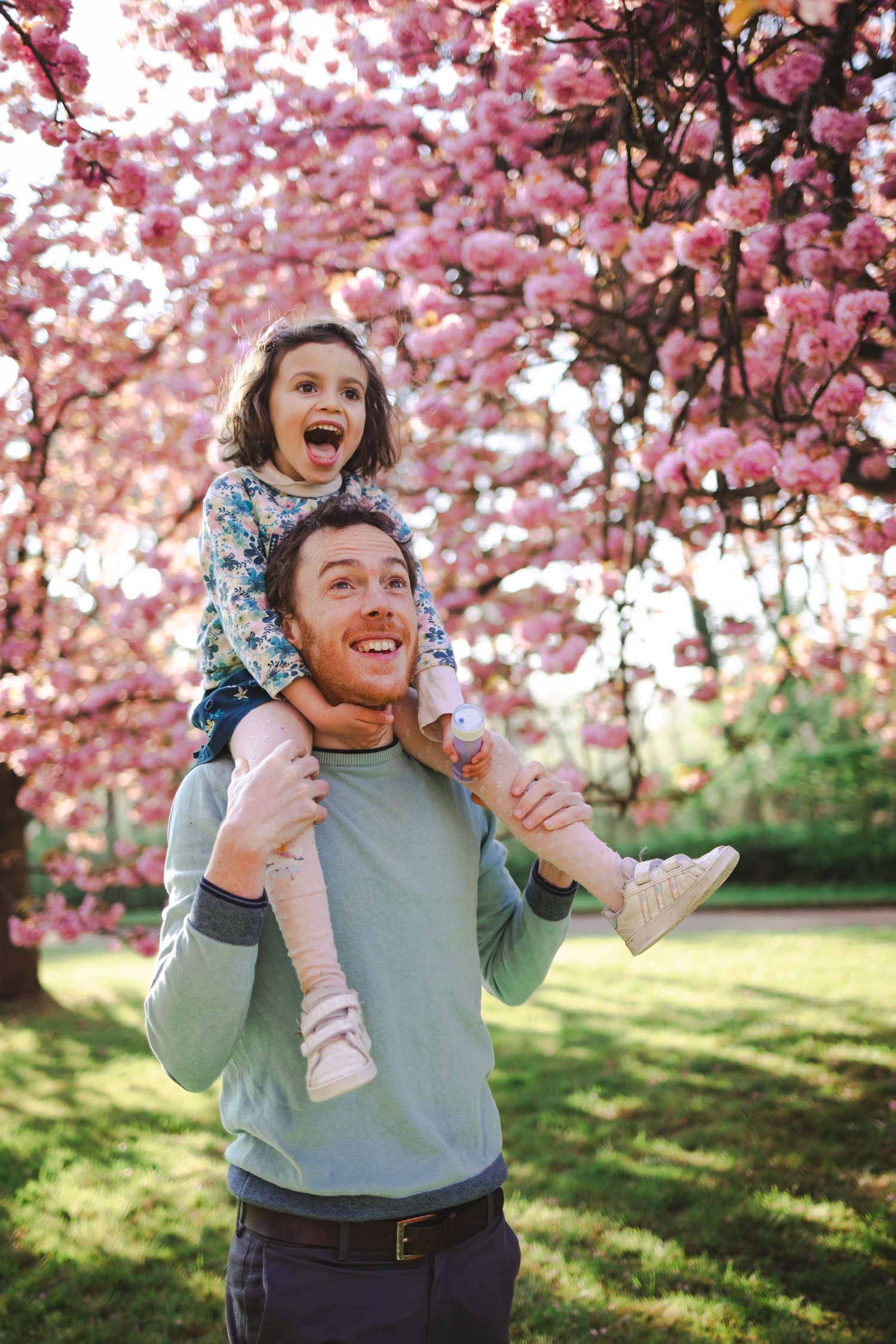 Un papa porte sa fille sur les épaules à l'occasion d'une mini-séance photo en famille pour Hanami
