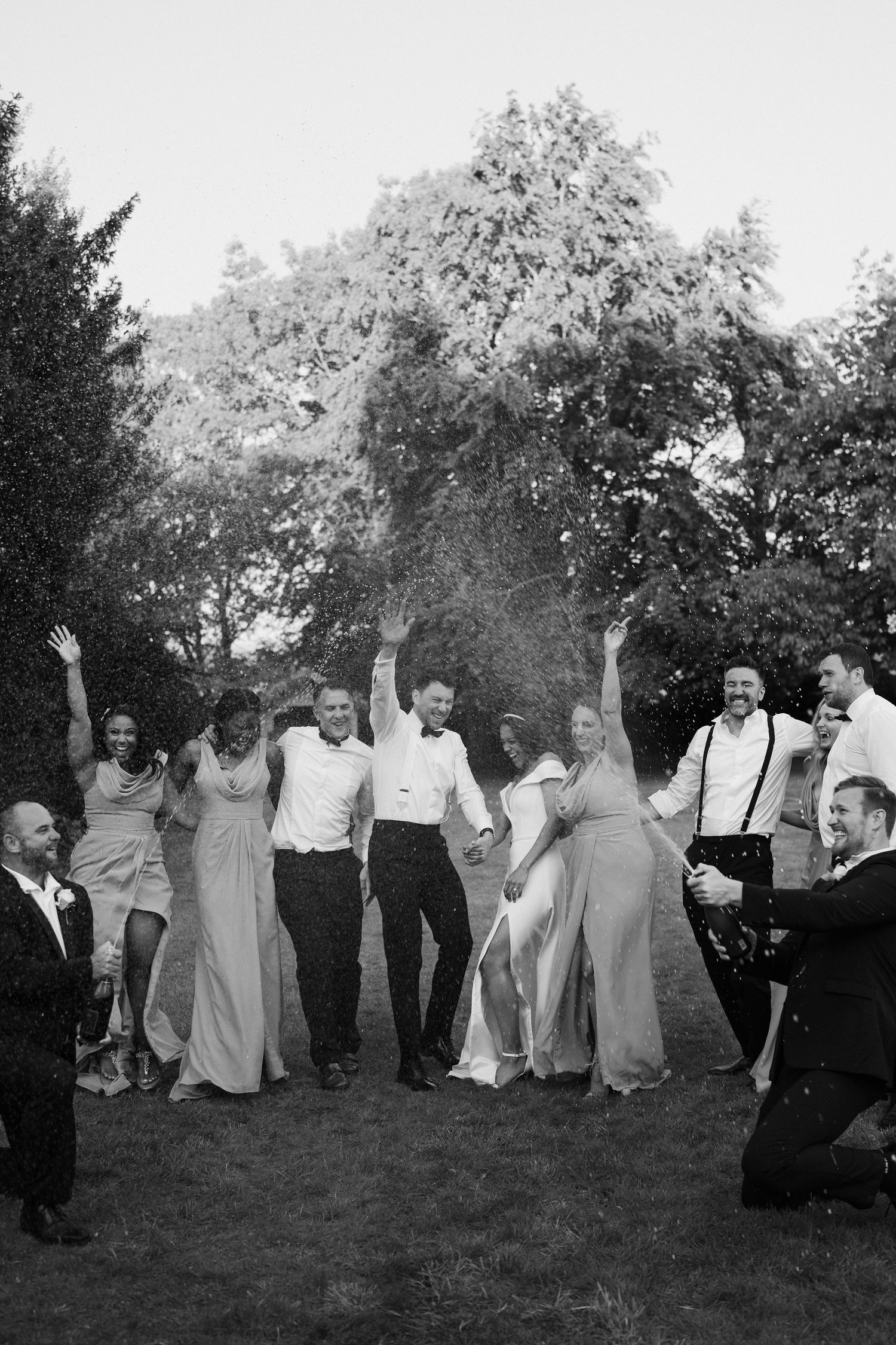 bride-and-groom-bridesmaids-groomsmen-spraying-champagne-stockton-house-wedding-shropshire