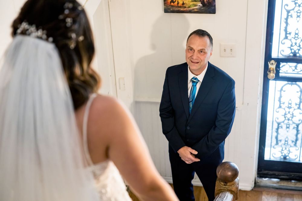 First look moment between two people in formal attire in bright indoor setting.