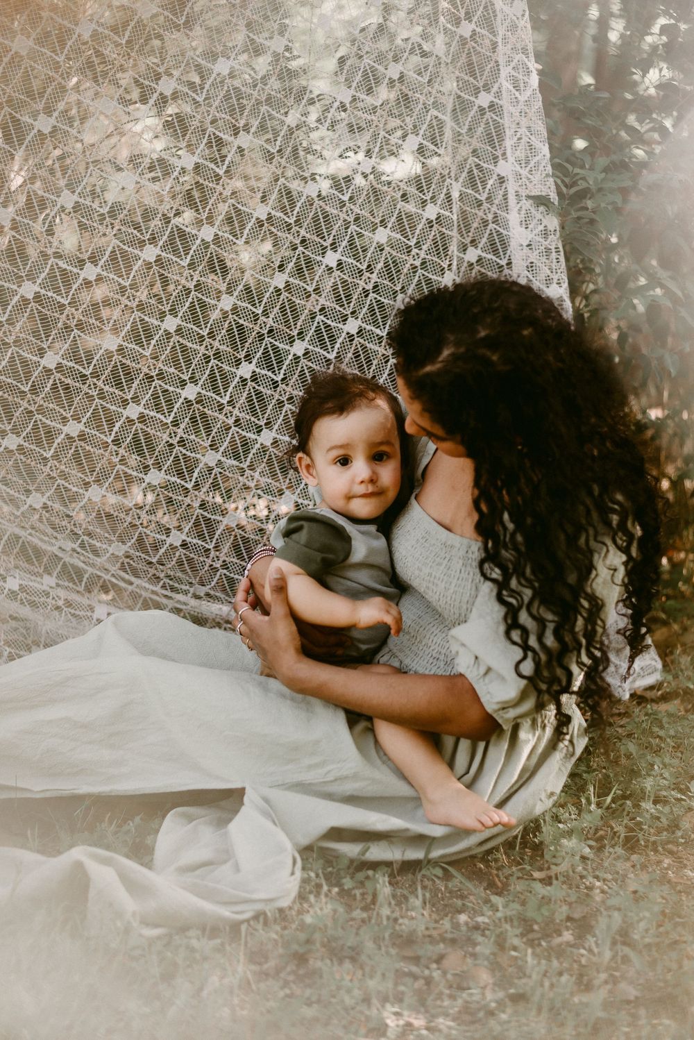 Artistic portrait on textured blanket showing intimate family connection in muted tones.