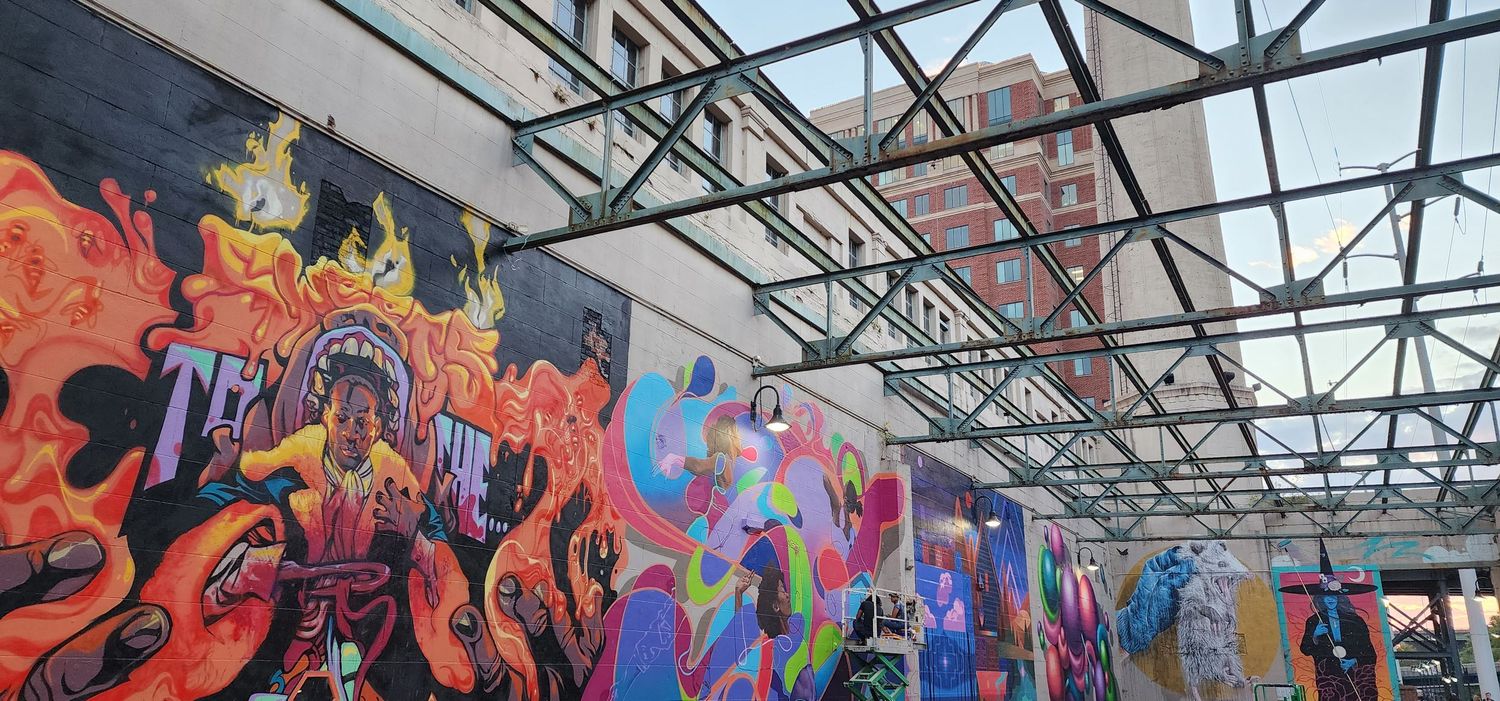 Colorful street art mural featuring vibrant flames and abstract designs under industrial ceiling.