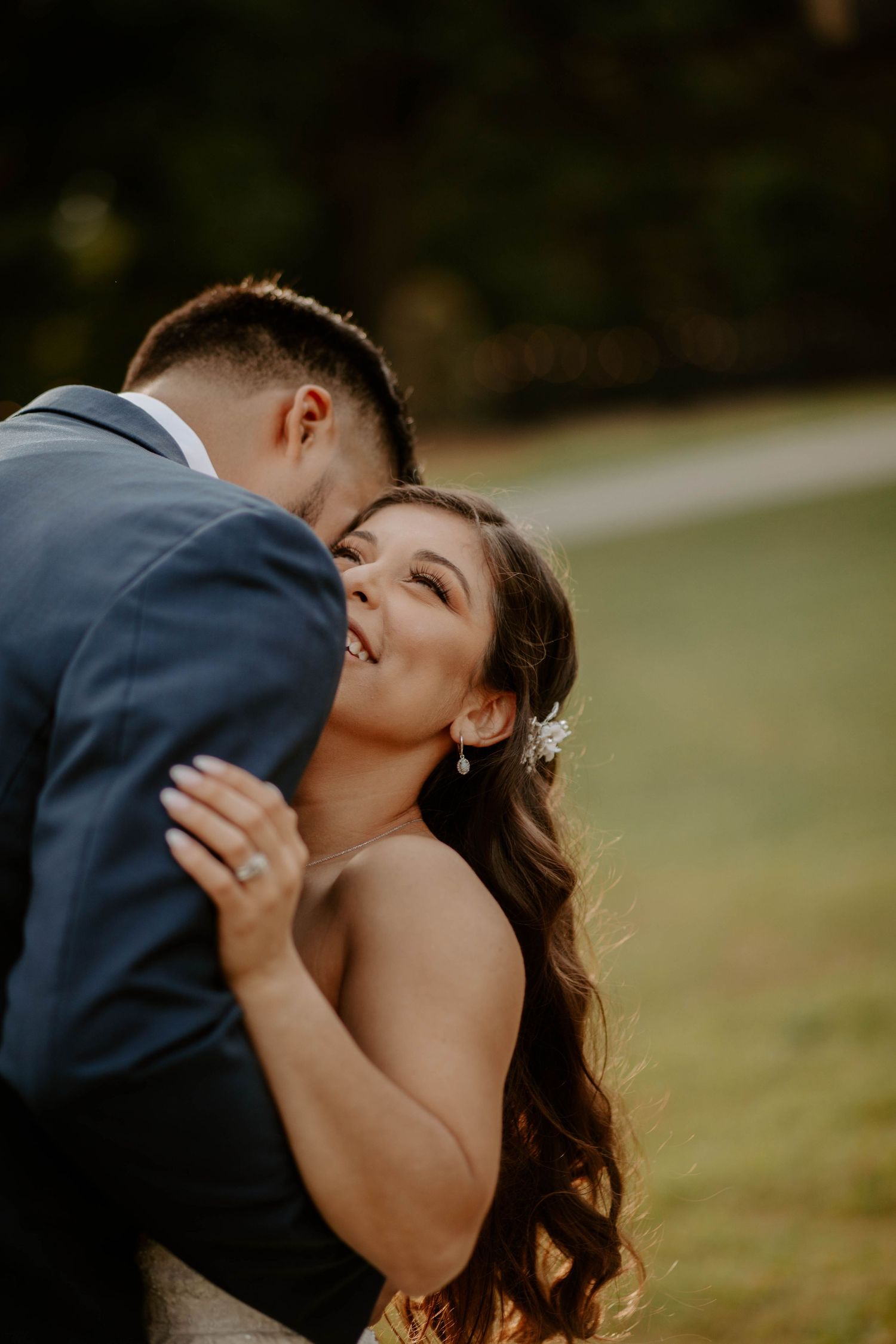 Smiling bride leans into the groom with a big smile on their wedding day.