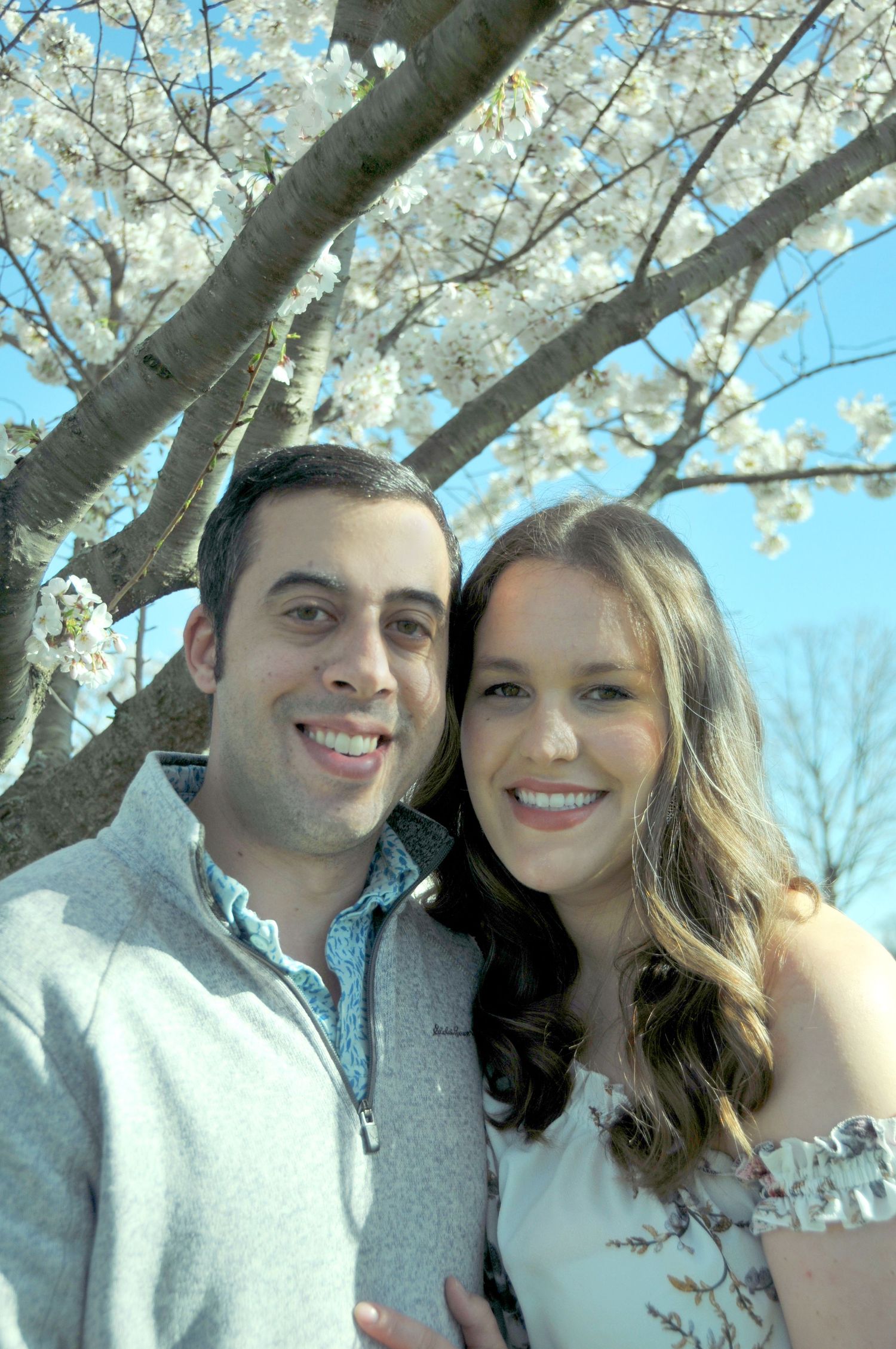 photo of couple outside with white blossoms