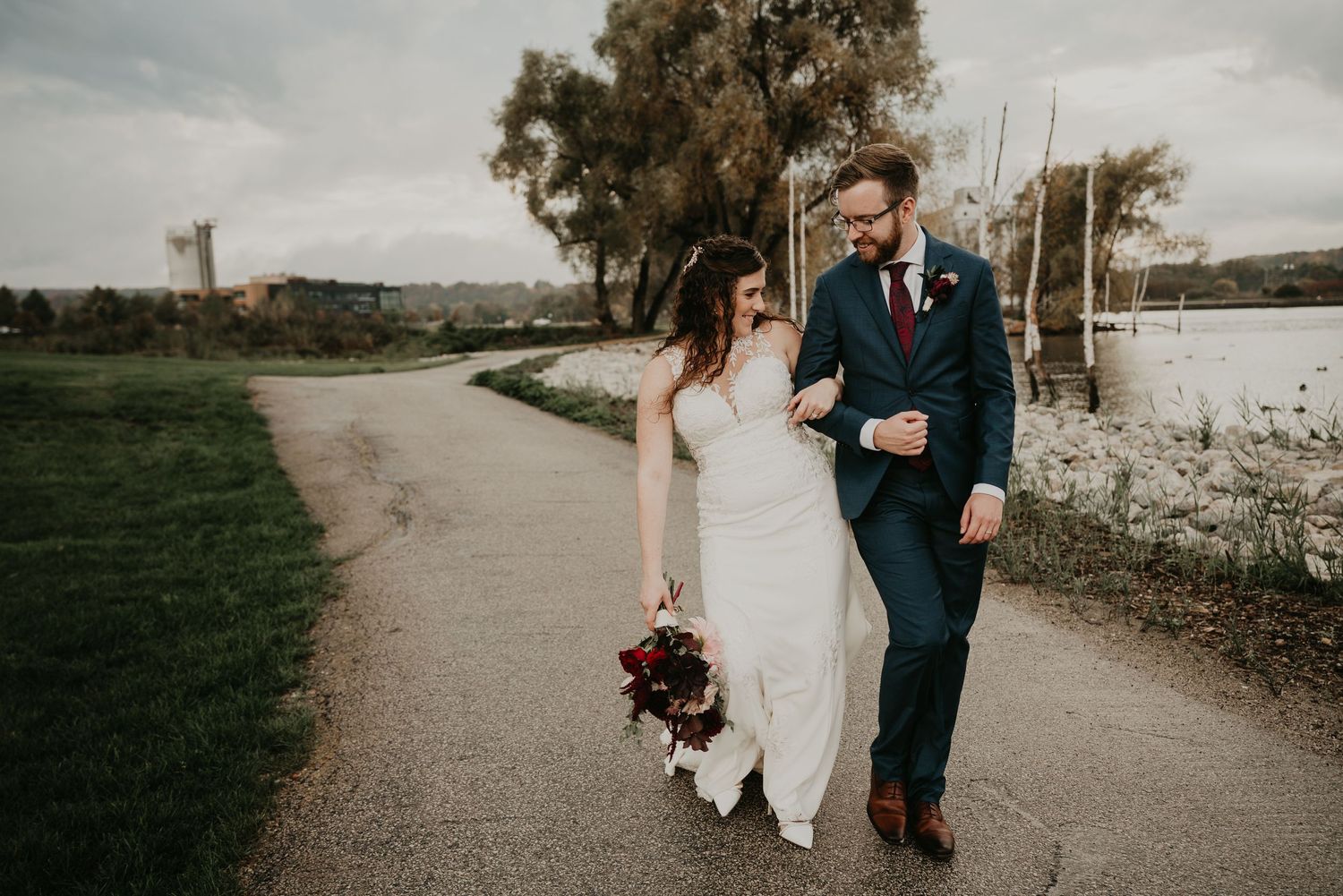 bride and groom bump hips as they walk